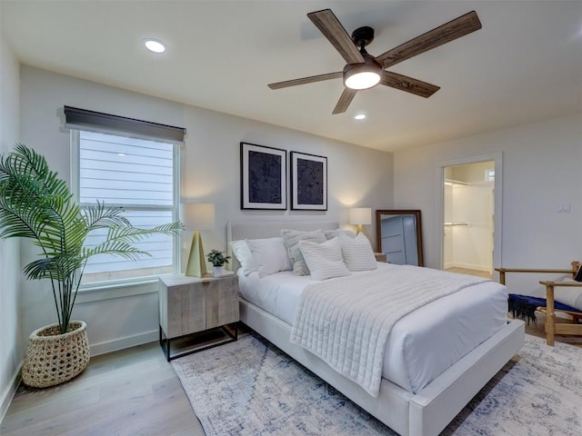 bedroom featuring light wood finished floors, recessed lighting, ensuite bathroom, a ceiling fan, and baseboards