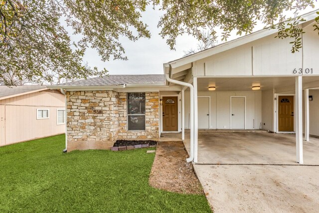 entrance to property featuring a yard and a carport