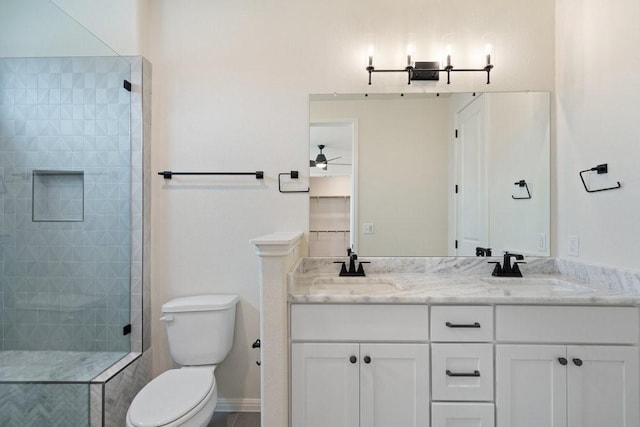 bathroom with vanity, toilet, and tiled shower