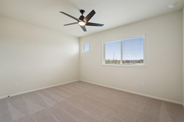 spare room featuring light colored carpet and ceiling fan