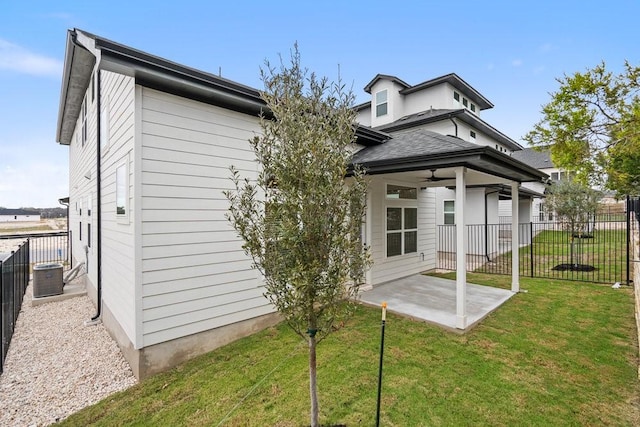 back of house with cooling unit, ceiling fan, a yard, and a patio area