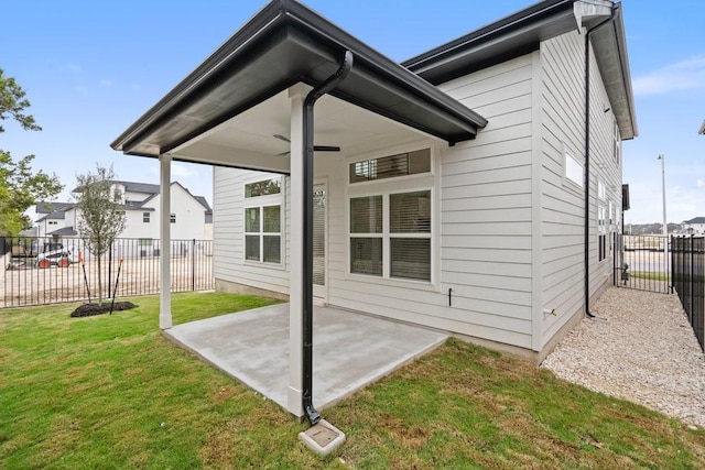 back of property with a yard, a patio, and ceiling fan