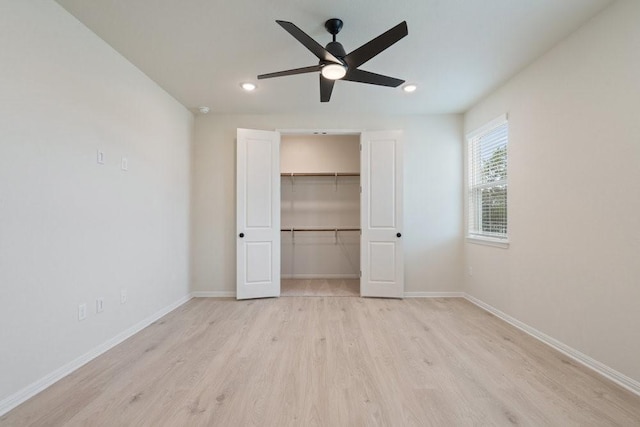 unfurnished bedroom with a walk in closet, light hardwood / wood-style flooring, a closet, and ceiling fan