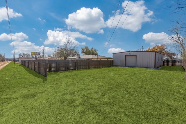 view of yard with a garage and an outbuilding