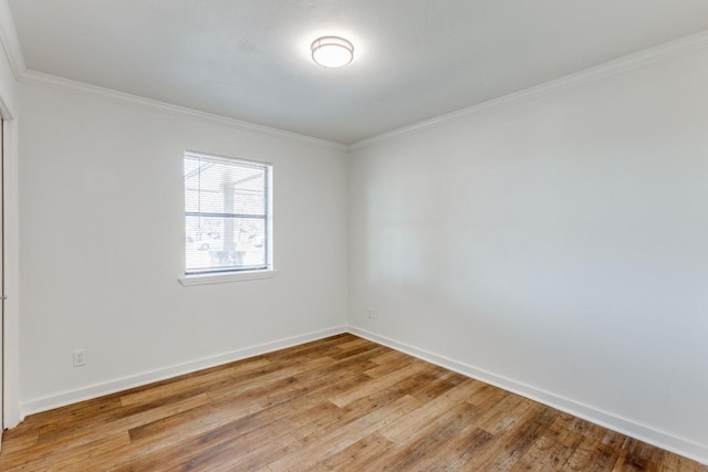 spare room with ornamental molding and light hardwood / wood-style flooring