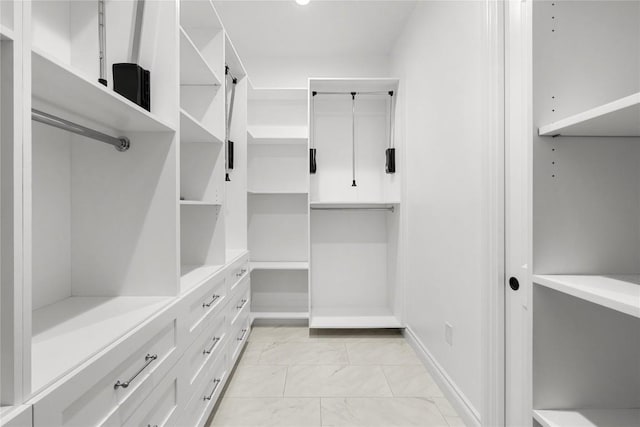 spacious closet featuring light marble finish flooring
