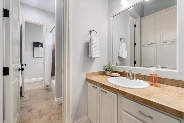 full bathroom with vanity, baseboards, and shower / bath combination with curtain