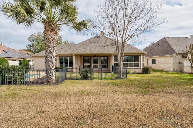 back of property featuring a fenced in pool and a yard