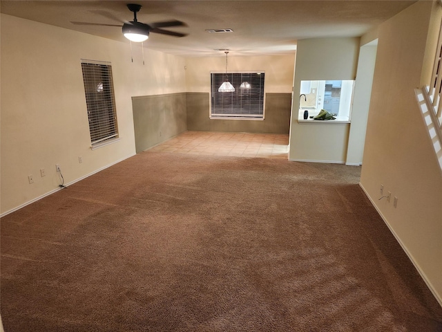 empty room with ceiling fan and light carpet