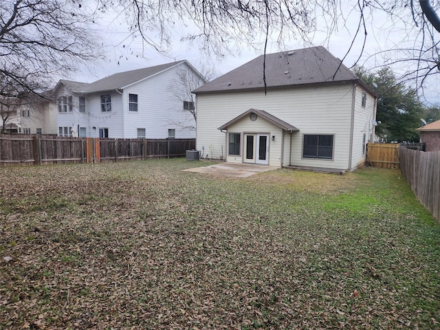 back of house with central AC, a yard, and a patio