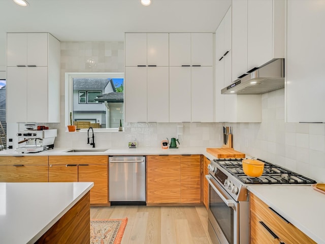 kitchen with sink, appliances with stainless steel finishes, backsplash, and white cabinetry