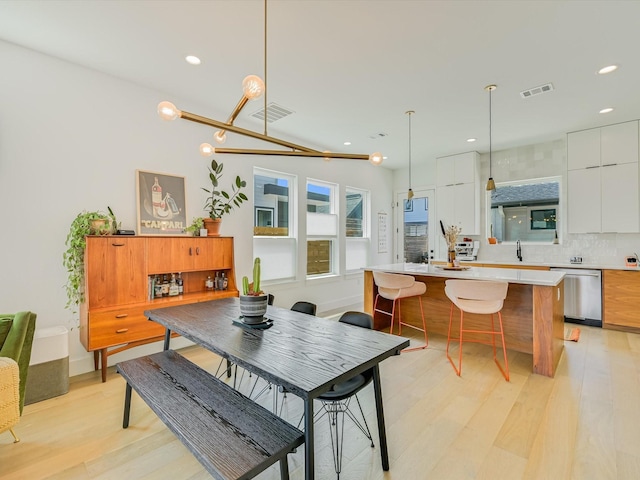 dining area featuring sink and light wood-type flooring