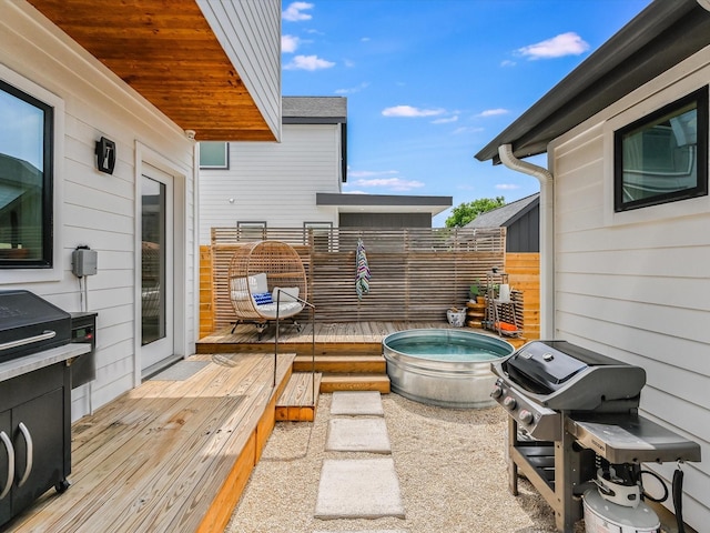 view of patio featuring a grill, a deck, and a jacuzzi