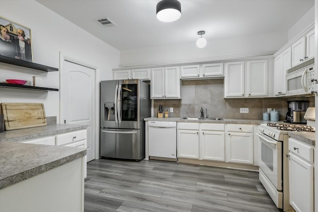 kitchen featuring white cabinetry, sink, and white appliances