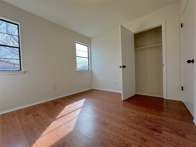 unfurnished bedroom with wood-type flooring and a closet