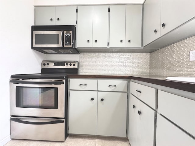 kitchen with decorative backsplash, light tile patterned floors, and stainless steel appliances