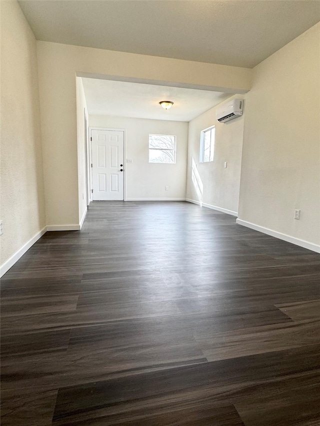 empty room with dark hardwood / wood-style floors and a wall mounted air conditioner