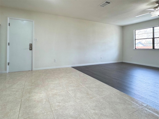 spare room with ceiling fan and light tile patterned floors