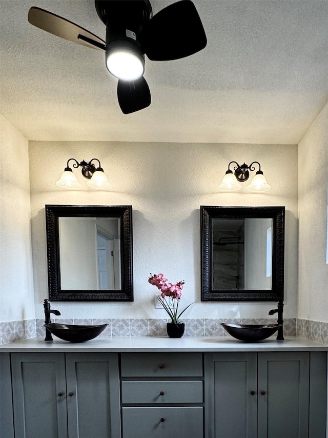 bathroom with a textured ceiling, ceiling fan, and vanity