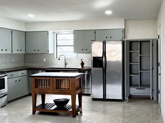 1206 Hackberry Dr, Marble Falls, TX 78654 - kitchen with stainless steel appliances, gray cabinetry, backsplash, dark countertops, and a sink