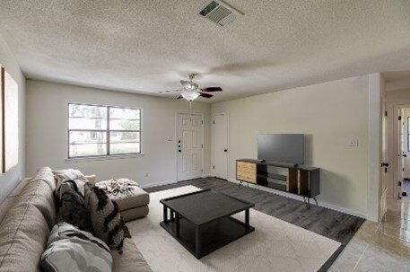 1206 Hackberry Dr, Marble Falls, TX 78654 - living room with a textured ceiling, ceiling fan, and baseboards