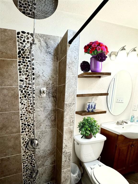 1206 Hackberry Dr, Marble Falls, TX 78654 - bathroom featuring tiled shower, vanity, and toilet