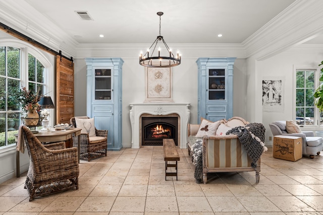 sitting room with ornamental molding, a barn door, and an inviting chandelier