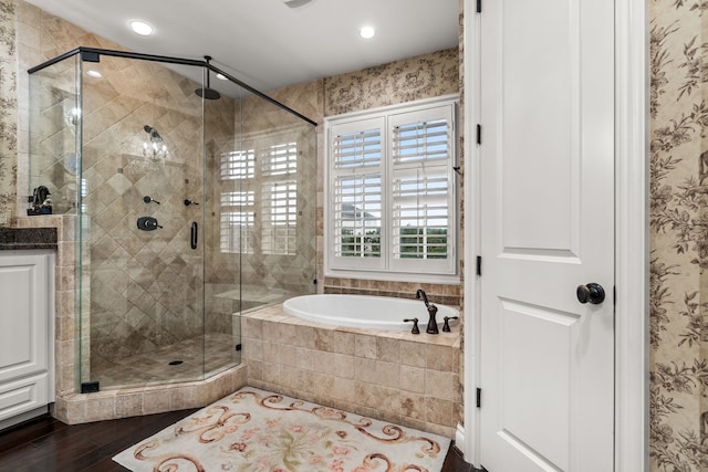 bathroom featuring vanity, wood-type flooring, and plus walk in shower