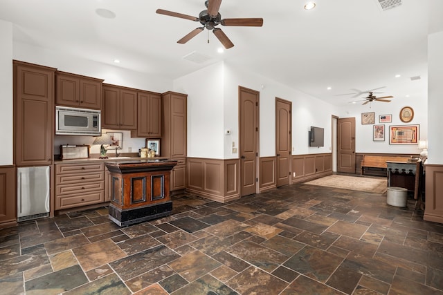 kitchen with stainless steel microwave, ceiling fan, and sink