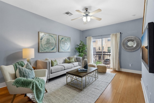 living room with ceiling fan and light hardwood / wood-style floors