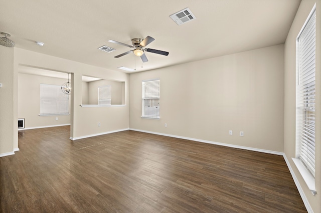 interior space featuring ceiling fan with notable chandelier and dark hardwood / wood-style flooring