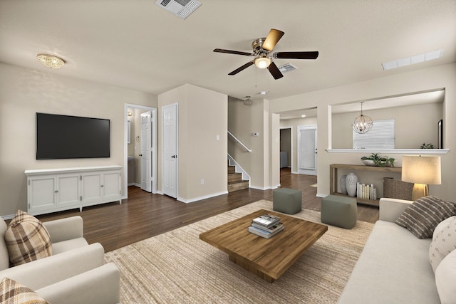 living room with ceiling fan with notable chandelier and hardwood / wood-style floors