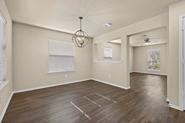 spare room featuring ceiling fan with notable chandelier and dark hardwood / wood-style flooring