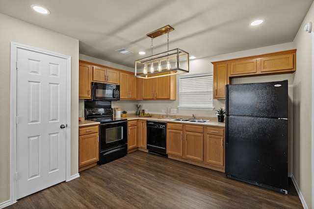 kitchen with dark wood-type flooring, pendant lighting, sink, and black appliances