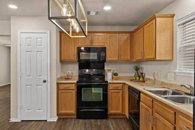 kitchen with black appliances, dark hardwood / wood-style flooring, sink, and hanging light fixtures