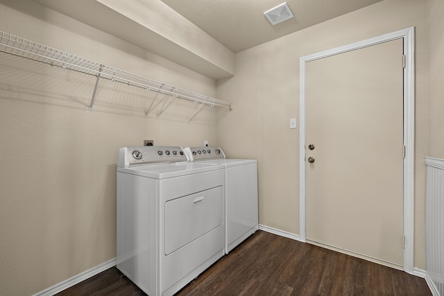 clothes washing area featuring washing machine and dryer and dark wood-type flooring