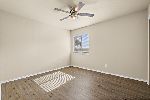 spare room with ceiling fan and dark hardwood / wood-style flooring