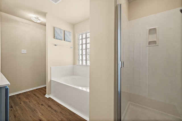 bathroom with hardwood / wood-style floors, vanity, and separate shower and tub