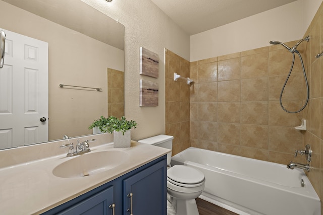 full bathroom with toilet, tiled shower / bath, and vanity