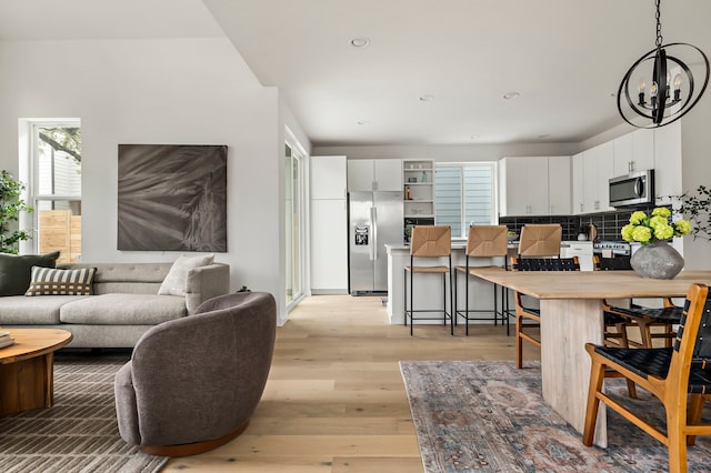 living room featuring an inviting chandelier and light hardwood / wood-style flooring