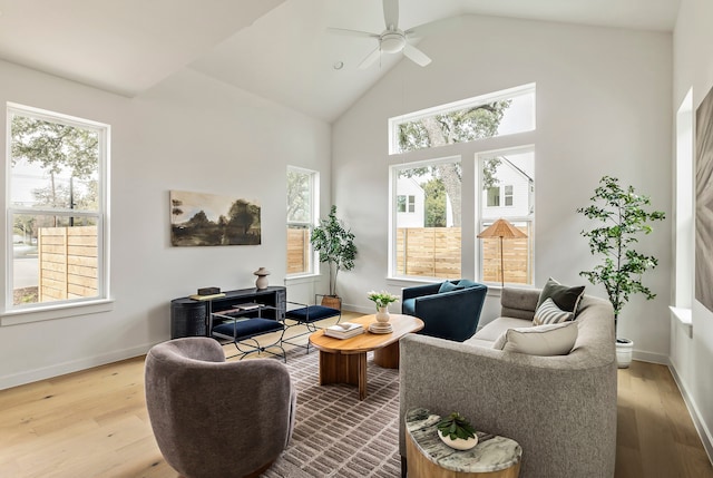 living room with ceiling fan, lofted ceiling, and light hardwood / wood-style flooring