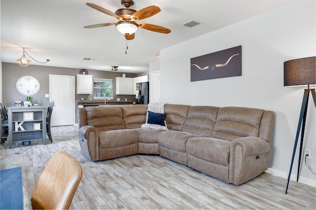 living room with ceiling fan and light wood-type flooring