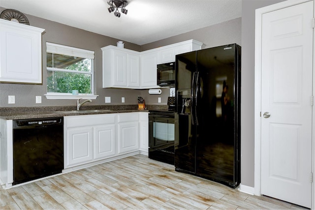 kitchen with black appliances, white cabinets, and sink