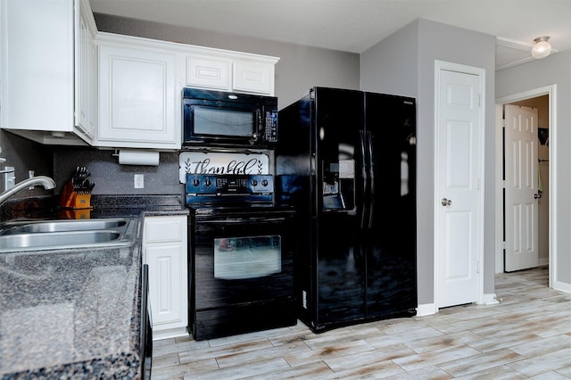 kitchen featuring sink, white cabinets, and black appliances