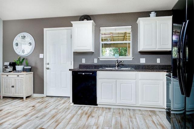 kitchen with sink, white cabinets, dark stone counters, and black appliances