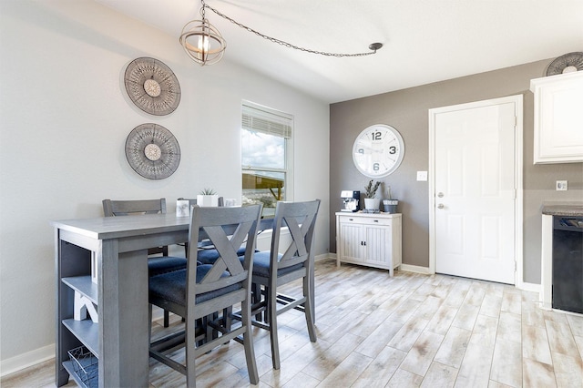 dining room featuring light wood-type flooring and a notable chandelier