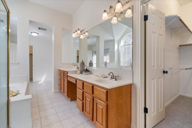 bathroom featuring vanity, a notable chandelier, tile patterned floors, and a washtub