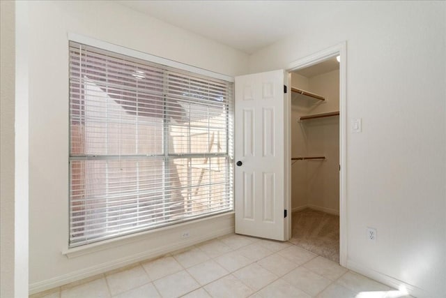 unfurnished bedroom featuring a spacious closet and a closet