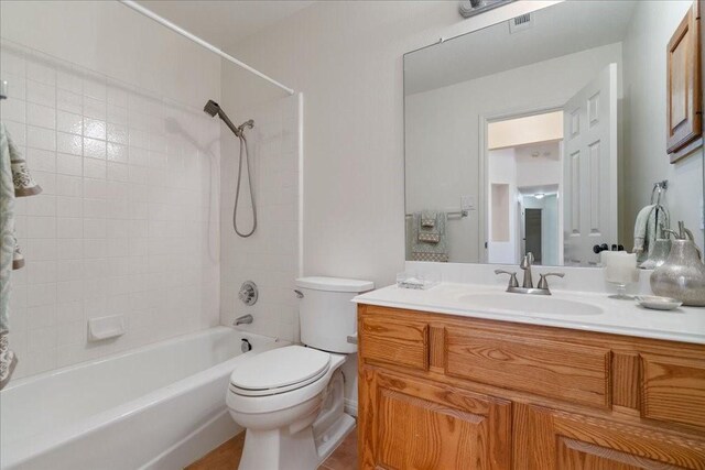 full bathroom with toilet, tiled shower / bath combo, and vanity