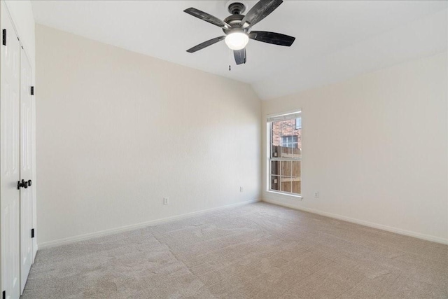 unfurnished room with carpet flooring, vaulted ceiling, baseboards, and ceiling fan